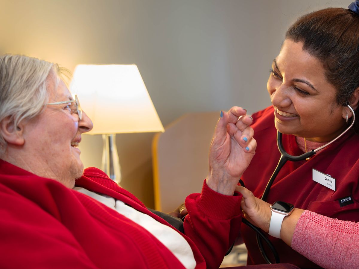 A nurse checking on a resident with a smile
