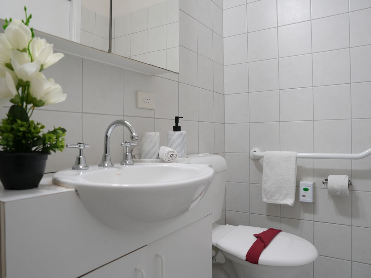 A bright accessible bathroom with support rails